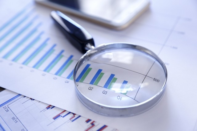 quarterly report paperwork with a magnifying glass on top