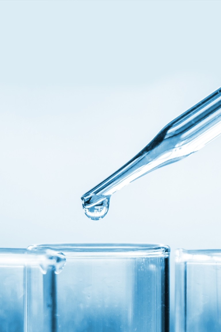 A glass test tube with a drop of liquid, showcasing a scientific experiment in progress